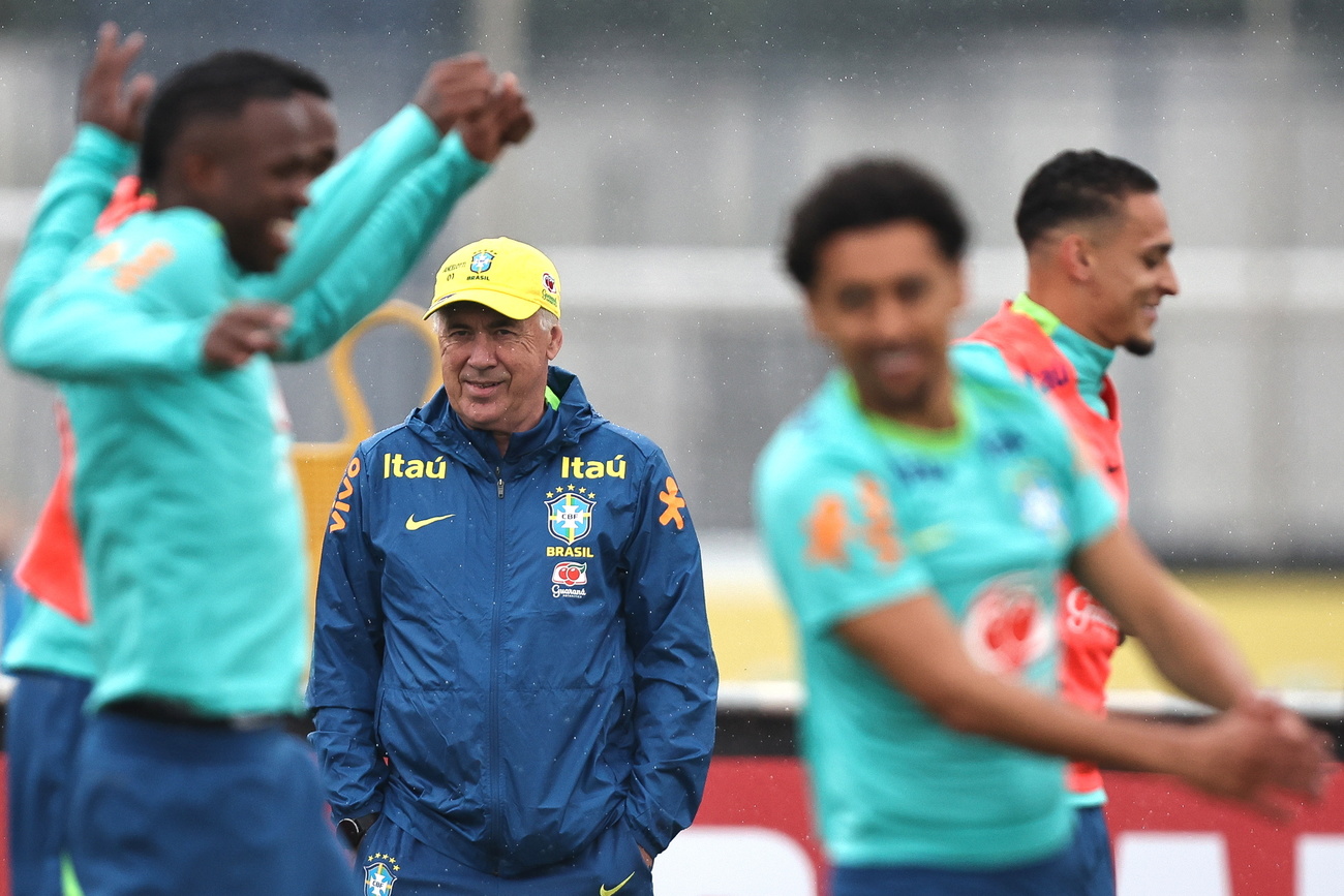 Treinador e jogadores de futebol treinando.